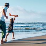 Back view of the family running along the coastline.