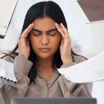 Stress, headache and burnout of business woman, overworked or overwhelmed by deadline or employees on office computer. Mental health, multitasking and frustrated female depressed in toxic workplace.